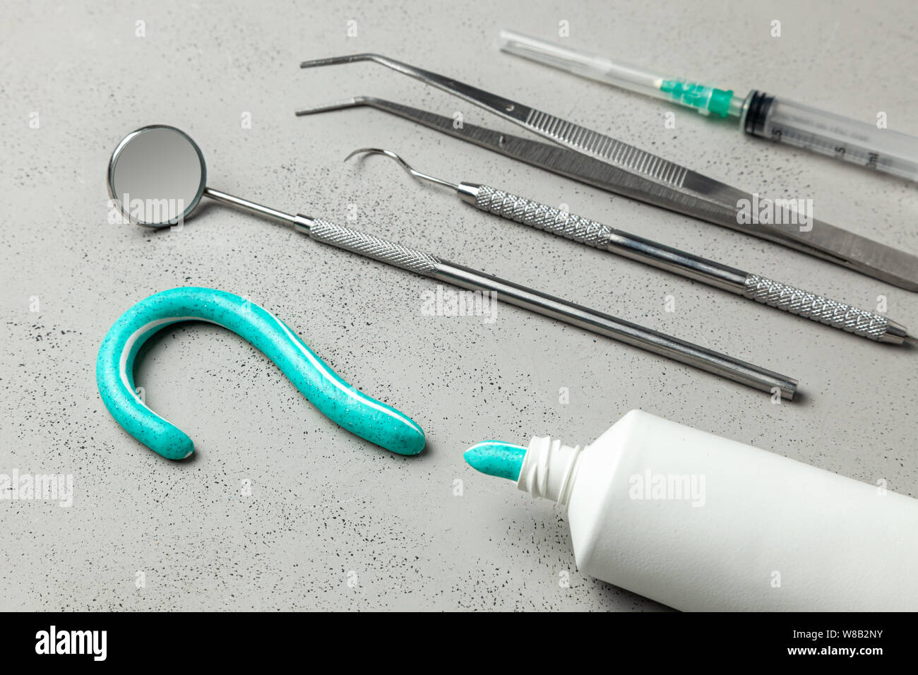 Gli strumenti del dentista e dentifricio a forma di punto interrogativo.  Specchietto gancio, pinzette e strumenti di siringa. Concetto di come  scegliere un dentista Foto stock - Alamy