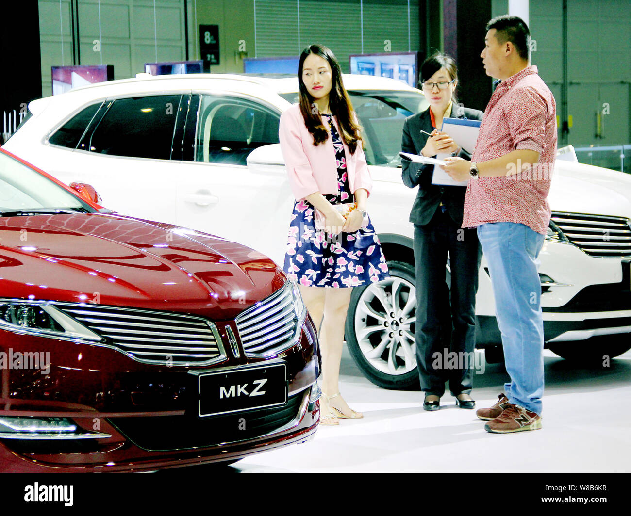 --FILE--i visitatori guardano una Lincoln MKZ sullo schermo durante un'auto show nella città di Nanjing East cinese della provincia di Jiangsu, 29 aprile 2016. Della Cina di passenge Foto Stock