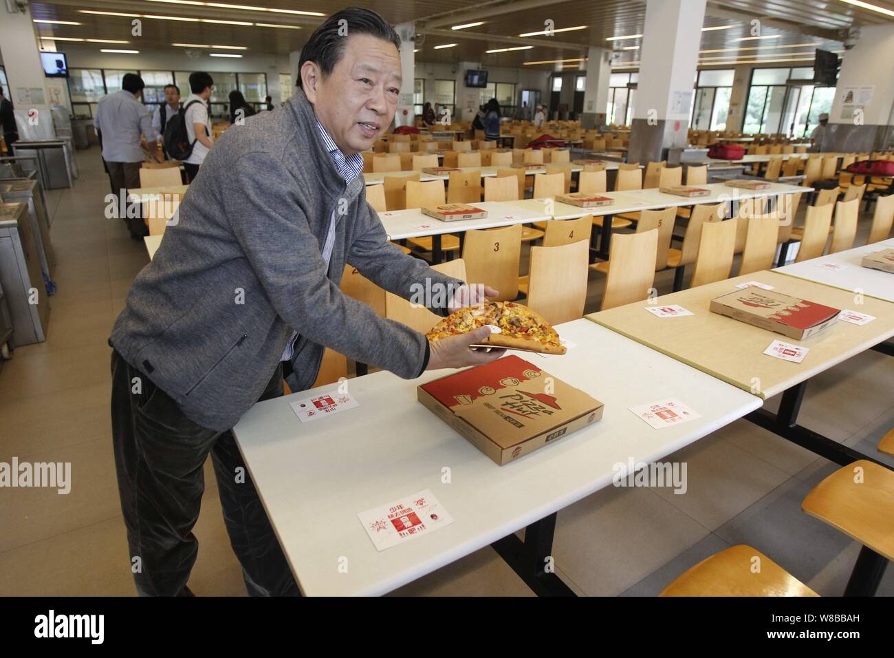 L'ex preside di una scuola prepara le pizze per laureandi in mensa a Zhengzhou city, centrale della Cina di Henan provinc Foto Stock
