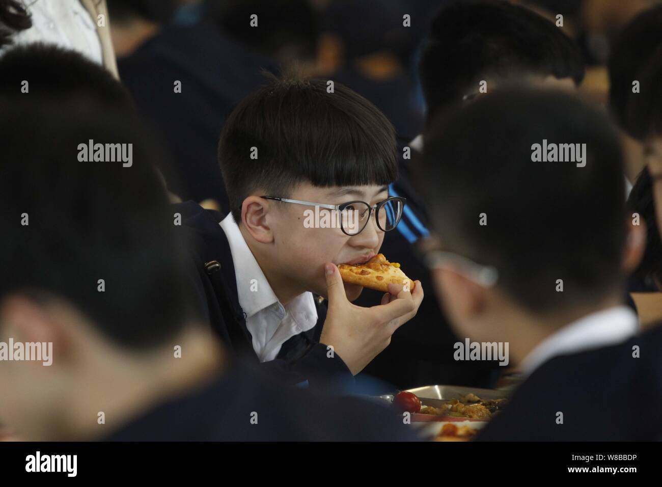 Un senior-anno degli studenti gode di pizza in mensa in una scuola nella città di Zhengzhou, centrale cinese della provincia di Henan, 9 maggio 2016. Senior-anno Foto Stock