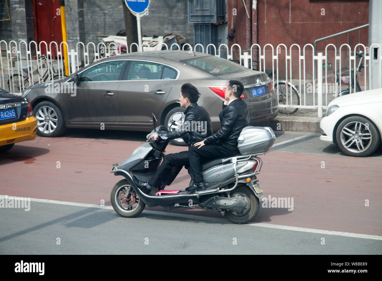 --FILE--ciclisti cinese di cavalcare una bicicletta elettrica su una strada a Pechino in Cina, 13 aprile 2016. Il crescente numero di auto private driver è in contrasto con Foto Stock
