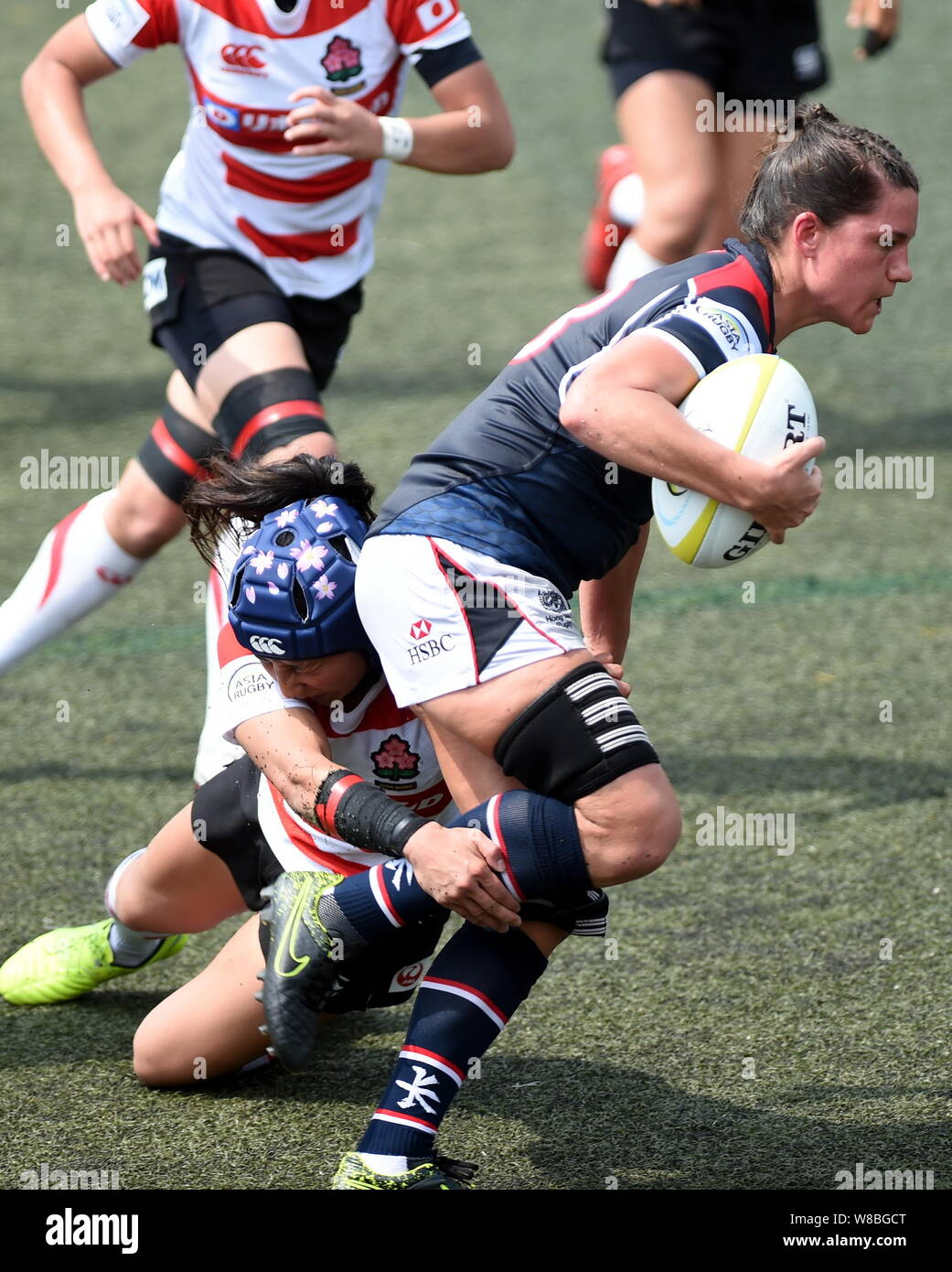 I giocatori del Giappone (rosso e bianco) e di Hong Kong di competere da una donna in una partita durante l'Asia campionato di rugby 2016 a Hong Kong, Cina, 7 maggio 2016. J Foto Stock