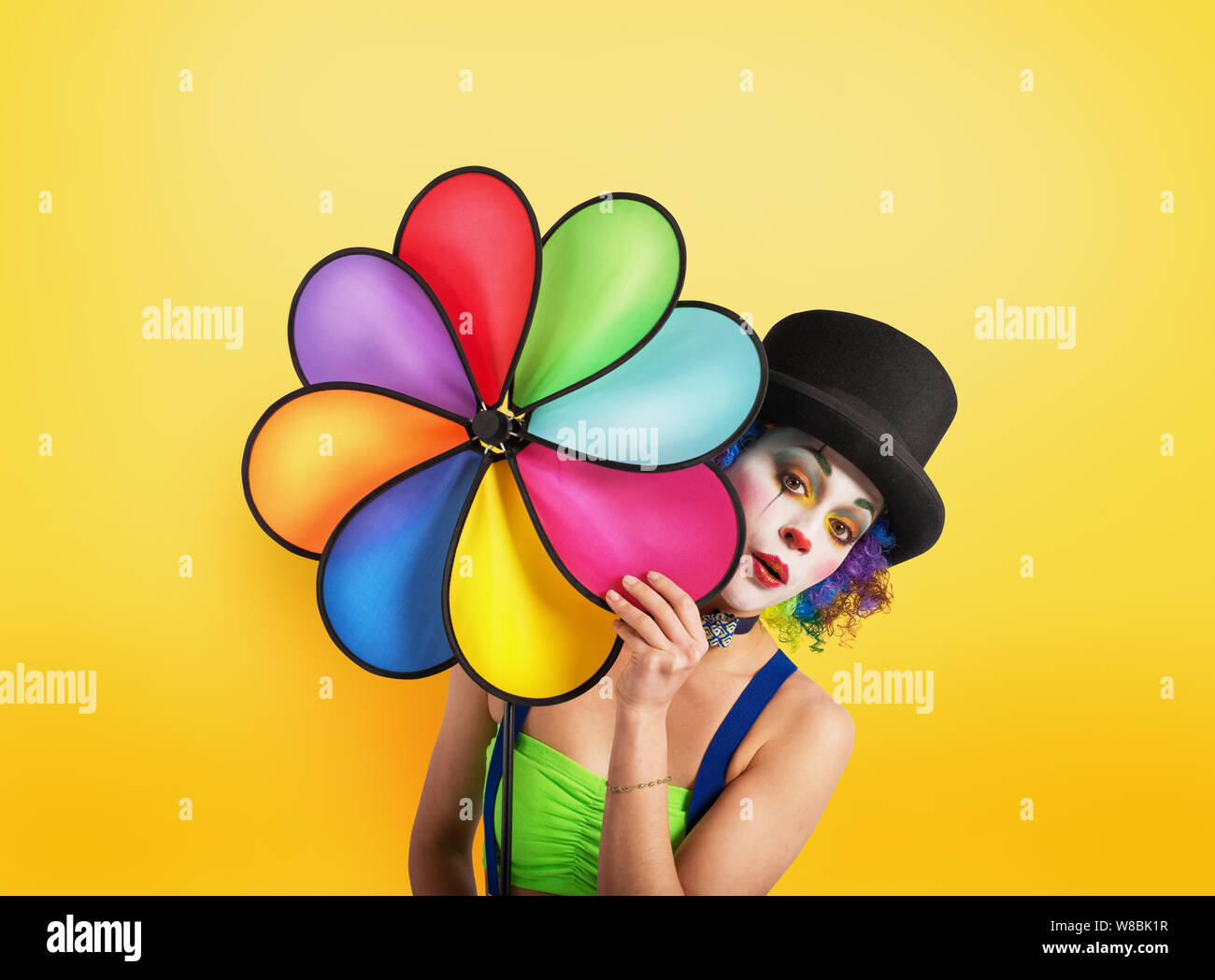 Clown con elica colorato su sfondo giallo Foto Stock