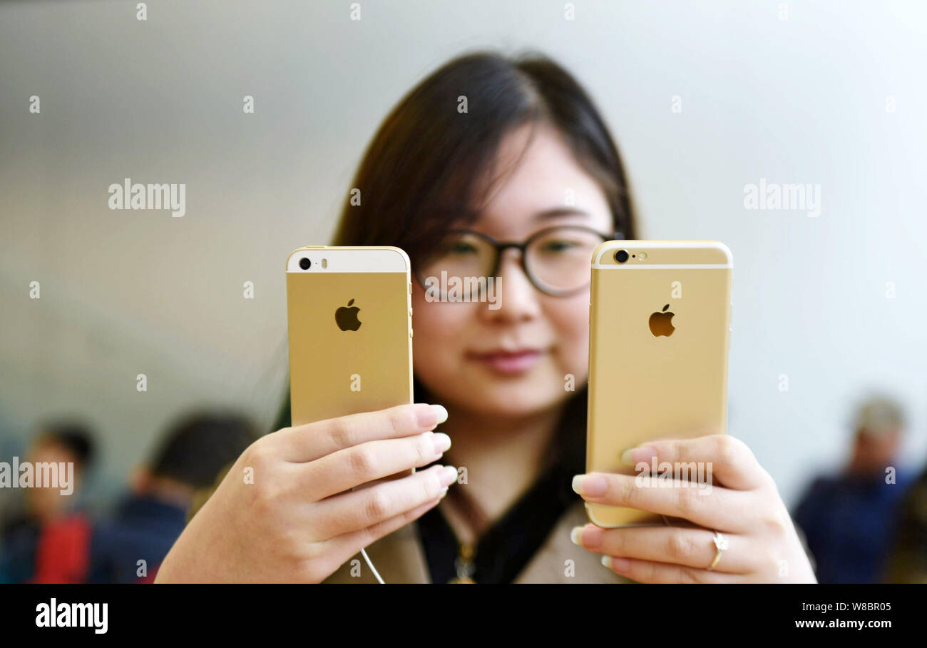 FILE--una ragazza cinese confronta un iPhone se lo smartphone, sinistra,  con un iPhone 6S a un Apple Store in Hangzhou, est della Cina di provincia  dello Zhejiang, 3 Foto stock - Alamy