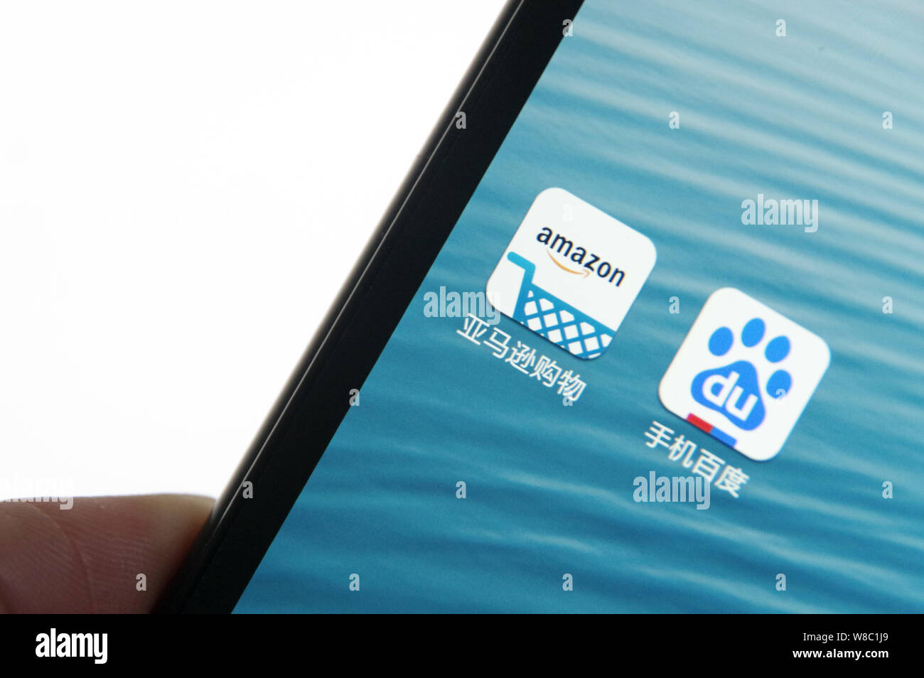 --FILE--un cinese telefono cellulare utente guarda le icone di Amazon, a sinistra, e Mobile Baidu sul suo smartphone di Jinan City, est della Cina di Shandong provin Foto Stock