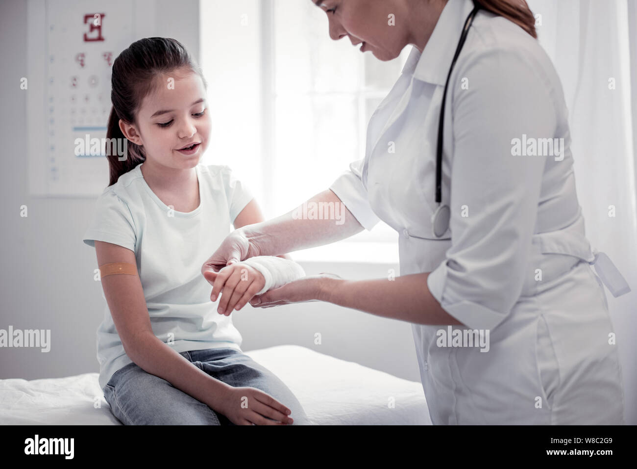 Bella ragazza piacevole mentre tiene il suo braccio nella parte anteriore della sua Foto Stock
