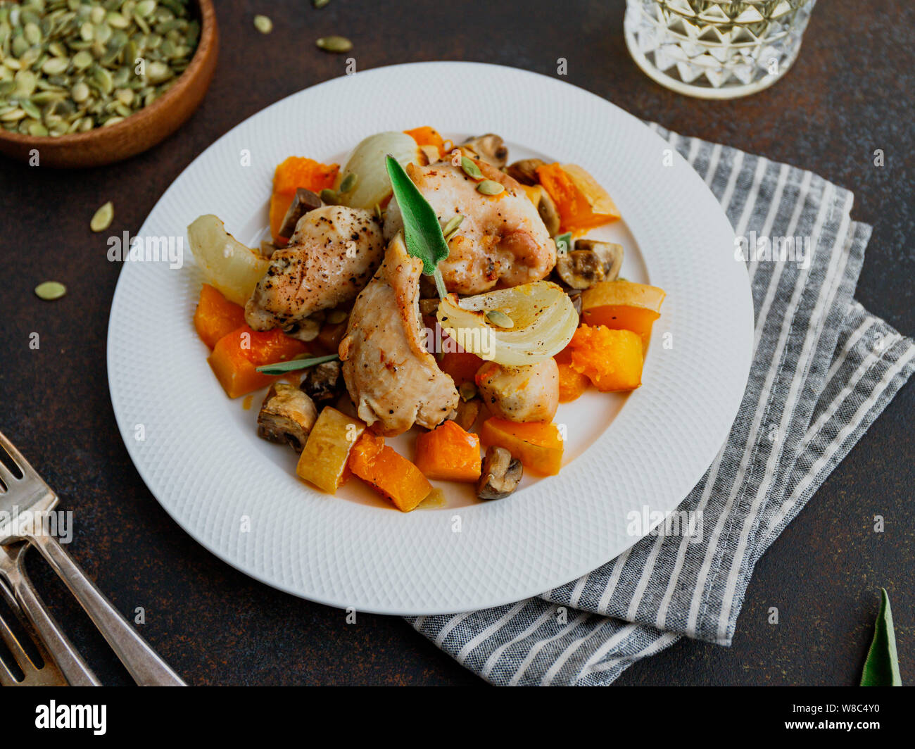 Autunno stagionali a basso contenuto calorico ricetta dalla Turchia al forno medaglioni con la zucca, cipolla, shampinions e salvia su una piastra bianca. Foto Stock