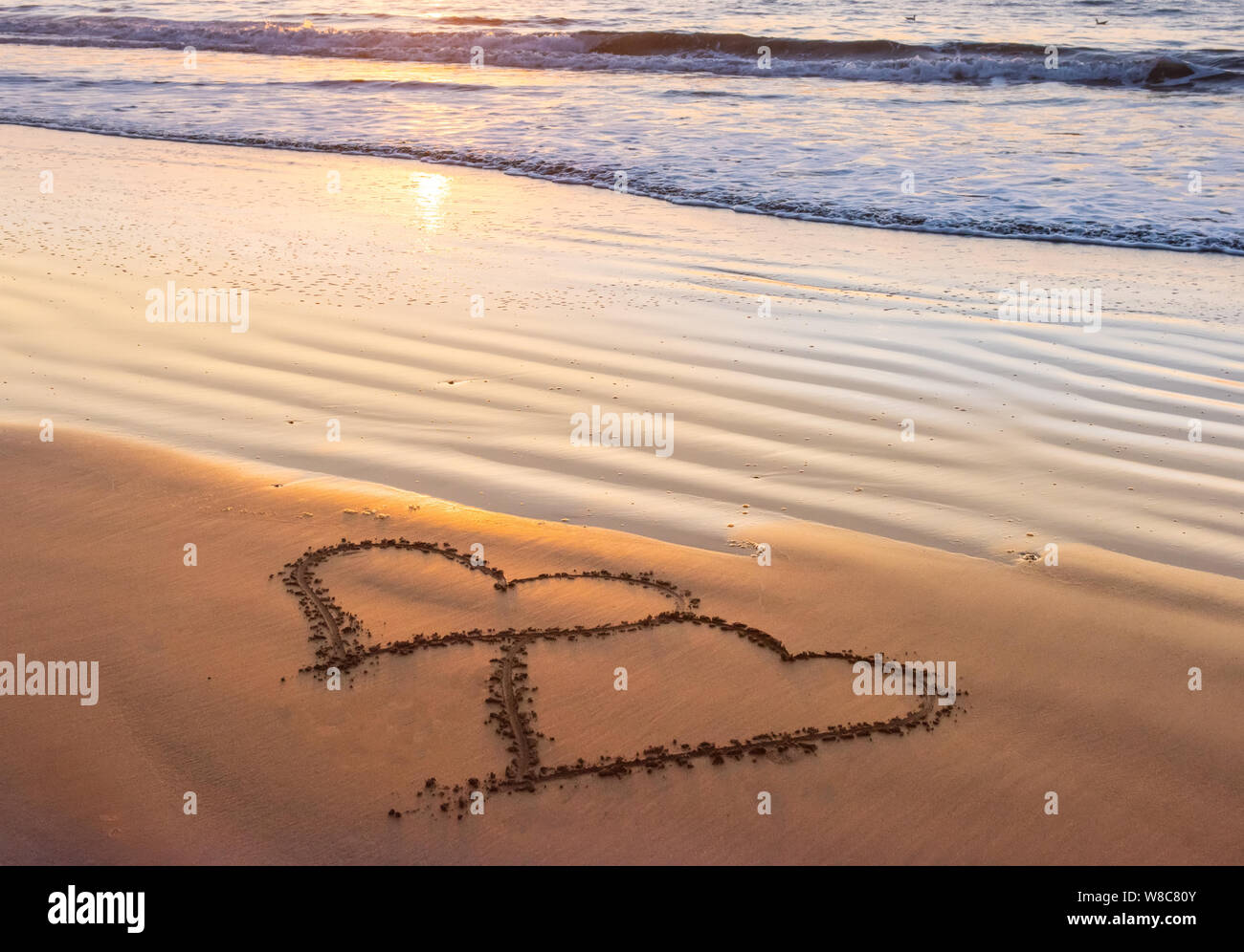 Giovane cuore sulla spiaggia del mare. Il giorno di San Valentino e il concetto di amore Foto Stock