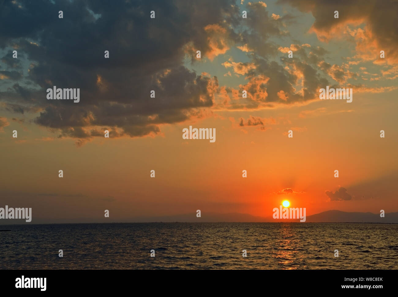 Scenario in mare con drammatica il cielo al tramonto Foto Stock