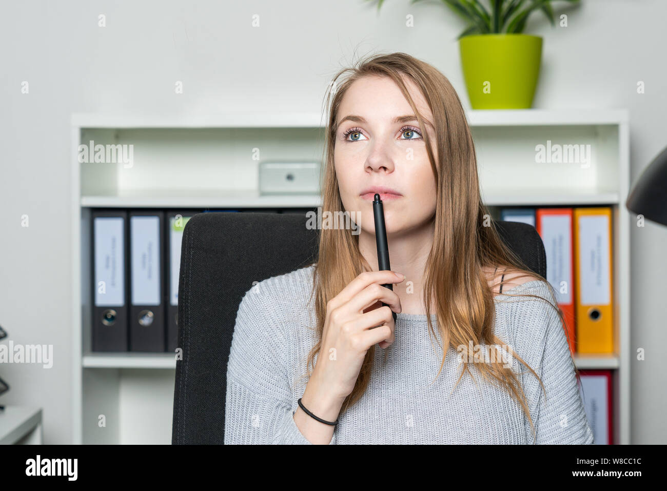 Giovane donna in ufficio ha un ispirazione Foto Stock