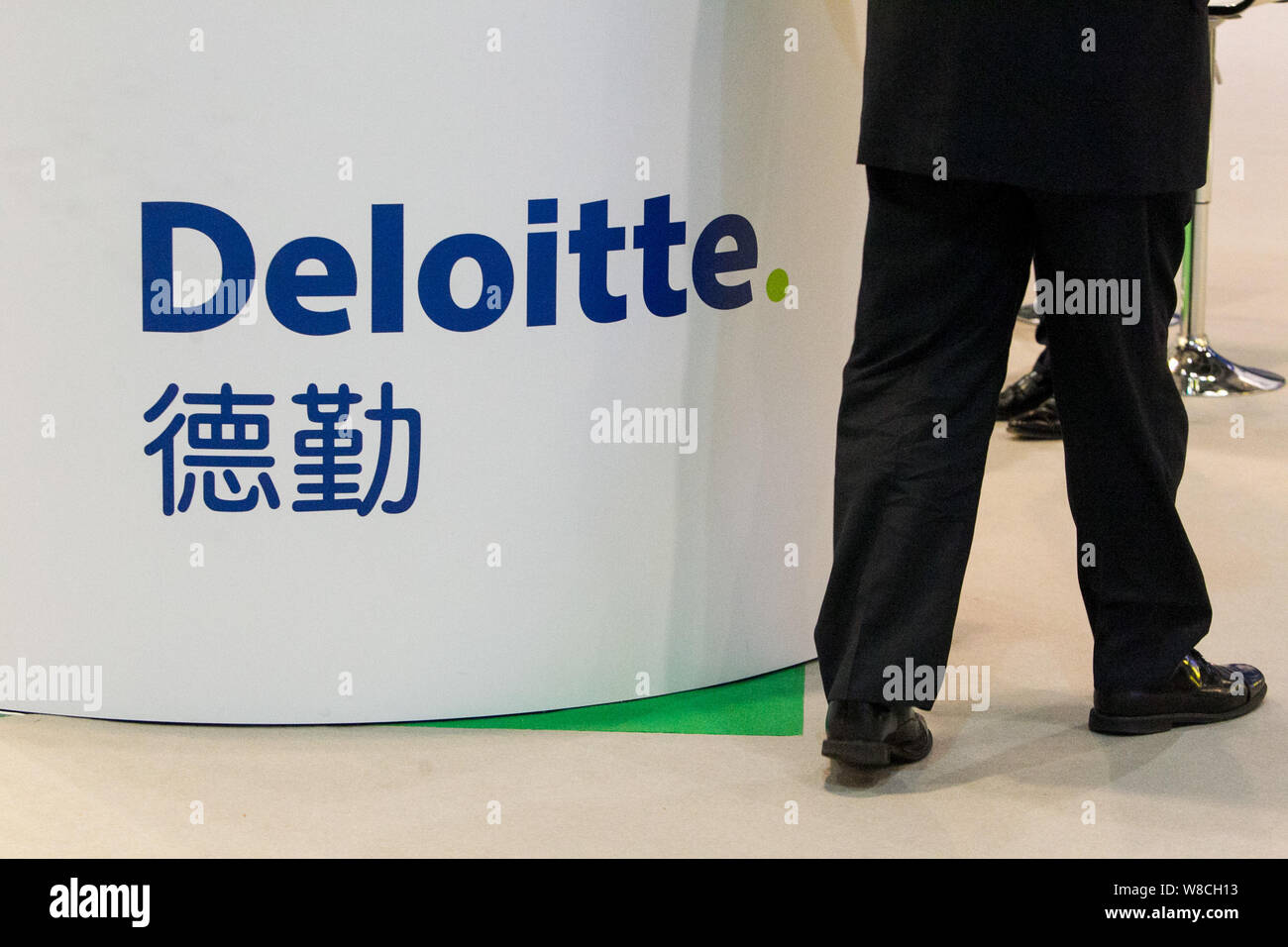 --FILE--un visitatore passeggiate passato lo stand della Deloitte durante una mostra a Hong Kong, Cina, 19 gennaio 2015. I cinesi affiliati dei Quattro Grandi Foto Stock