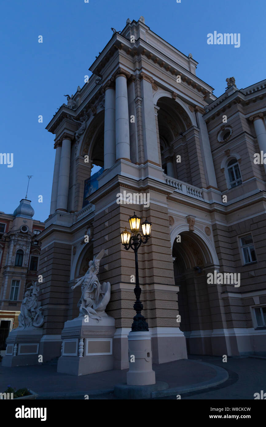 Ucraina Odessa, Lanzheronivska street, 13 giugno 2019. L'arco di entrata del palazzo dell'opera all'alba con un grande angelo scultura. Foto Stock