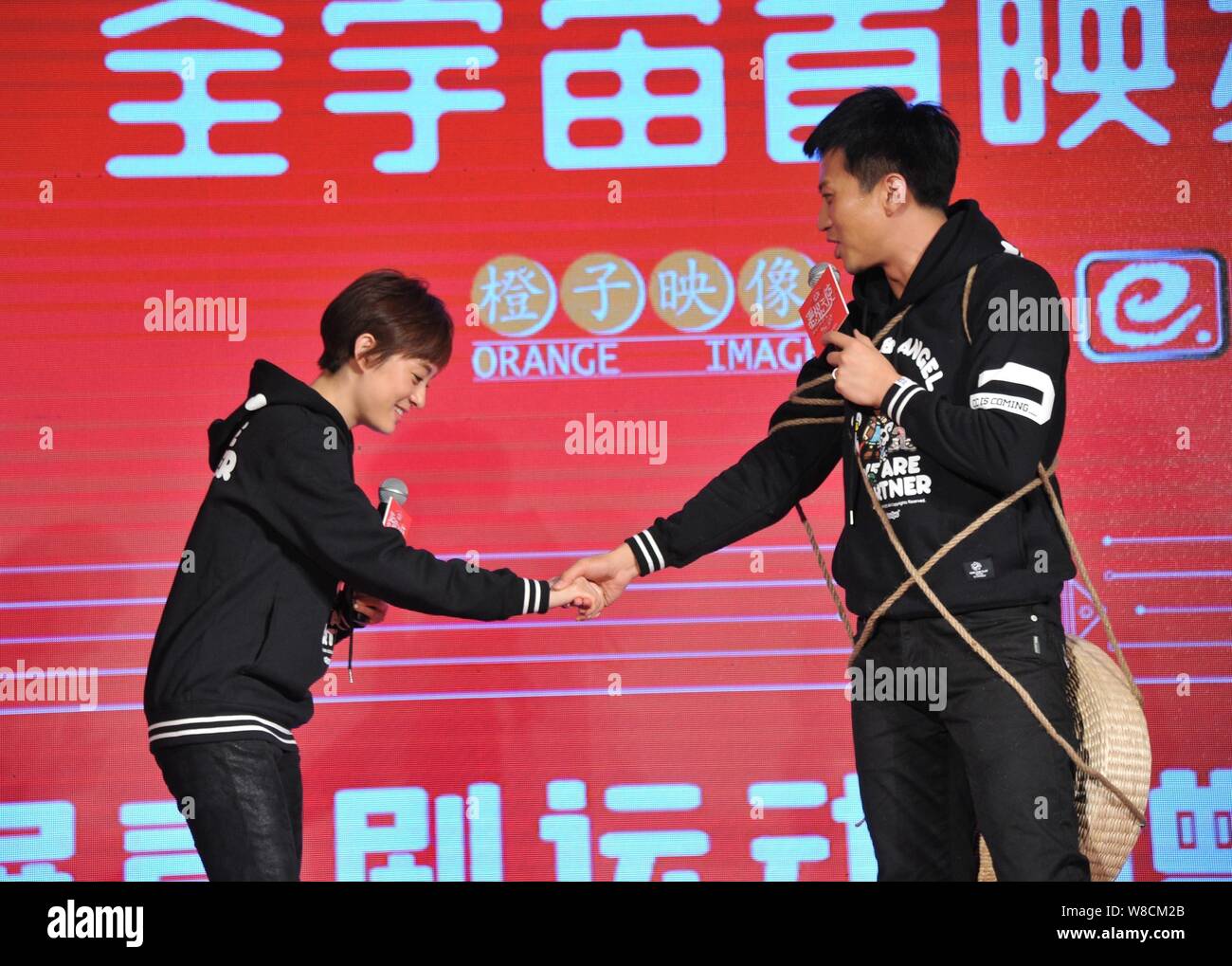 Attore cinese Deng Chao, destra parla come egli tiene per mano con la sua attrice moglie Sun Li in occasione di una conferenza stampa per la premiere del loro nuovo film 'Devil Foto Stock