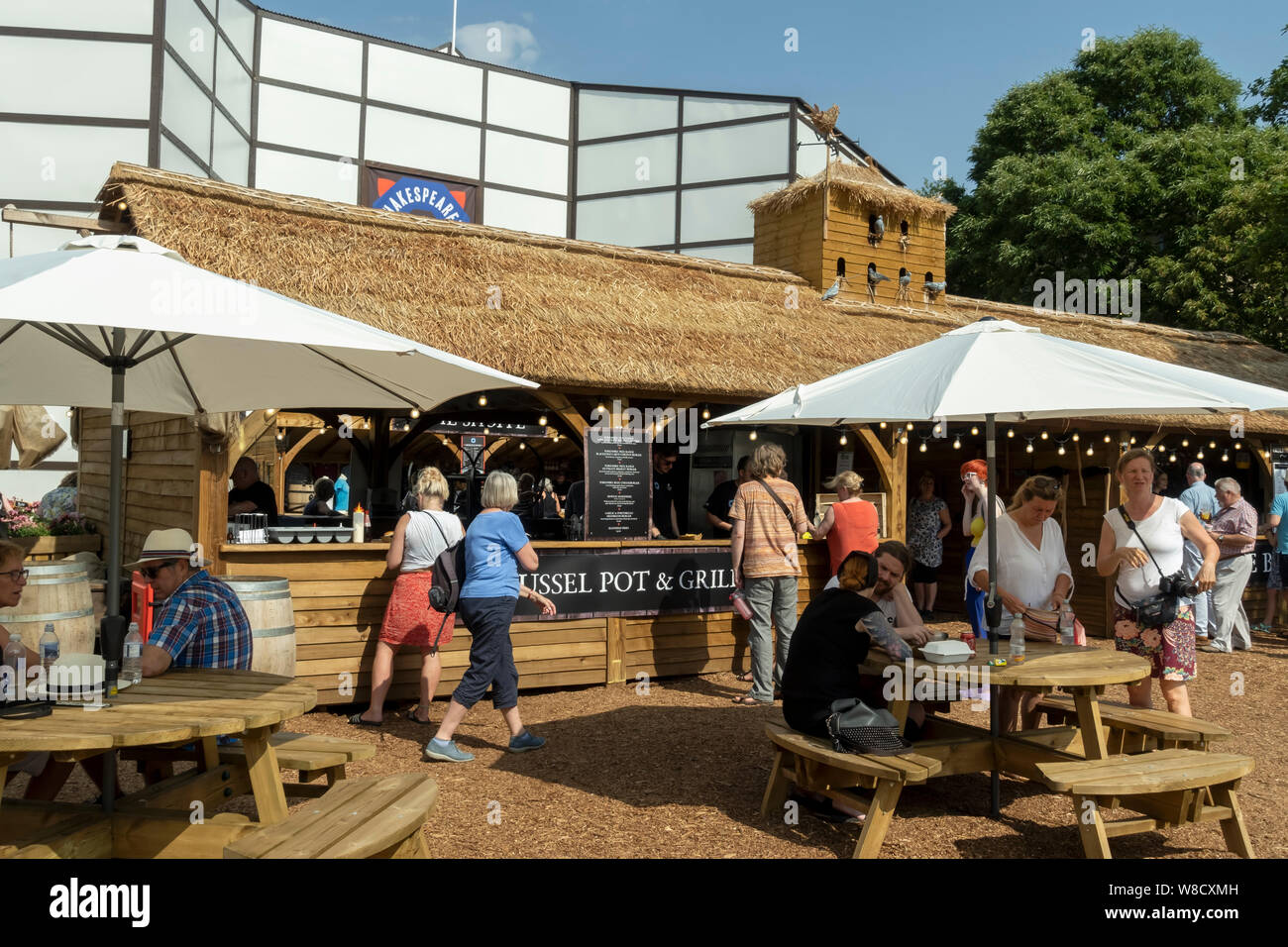 Persone al di fuori del Rose Theatre di Shakespeare bar e bancarelle alimentari del villaggio York North Yorkshire Inghilterra Regno Unito GB Gran Bretagna Foto Stock