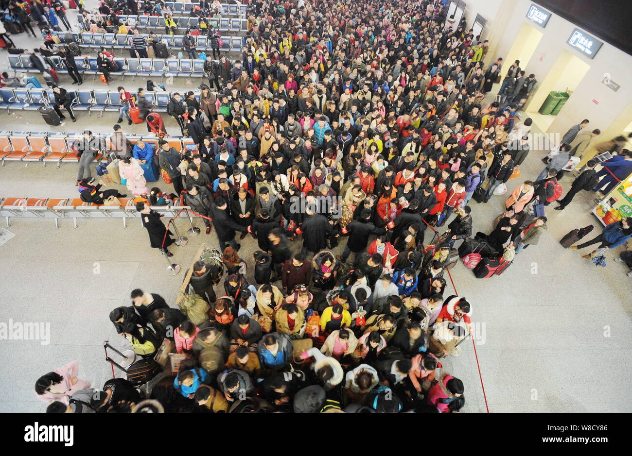 Una folla di passeggeri cinesi di attendere per il check-in presso la stazione ferroviaria Hankou stazione prima di prendere il treno per tornare a casa per la festa di primavera per celebrare il Foto Stock