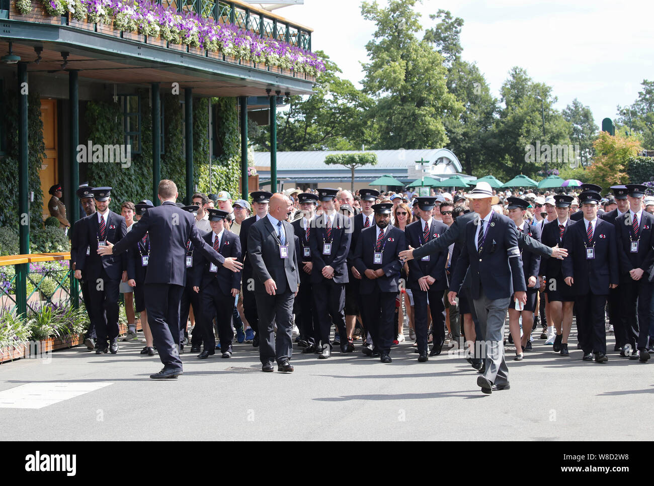 Il personale di sicurezza che conduce la folla sul terreno durante il 2019 campionati di Wimbledon, London, England, Regno Unito Foto Stock