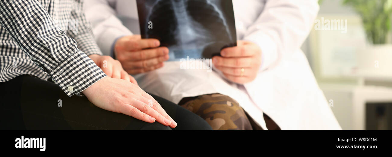 Medico paziente tiene x-ray e relazioni cattive notizie Foto Stock