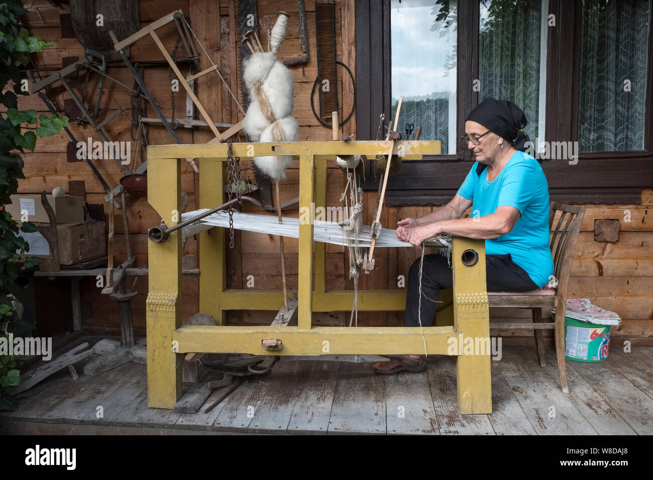 Una donna che lavora al suo telaio nel villaggio di Botiza, Maramureș, Romania. Il villaggio è noto per la sua lana intrecciato tappeti e moquette Foto Stock