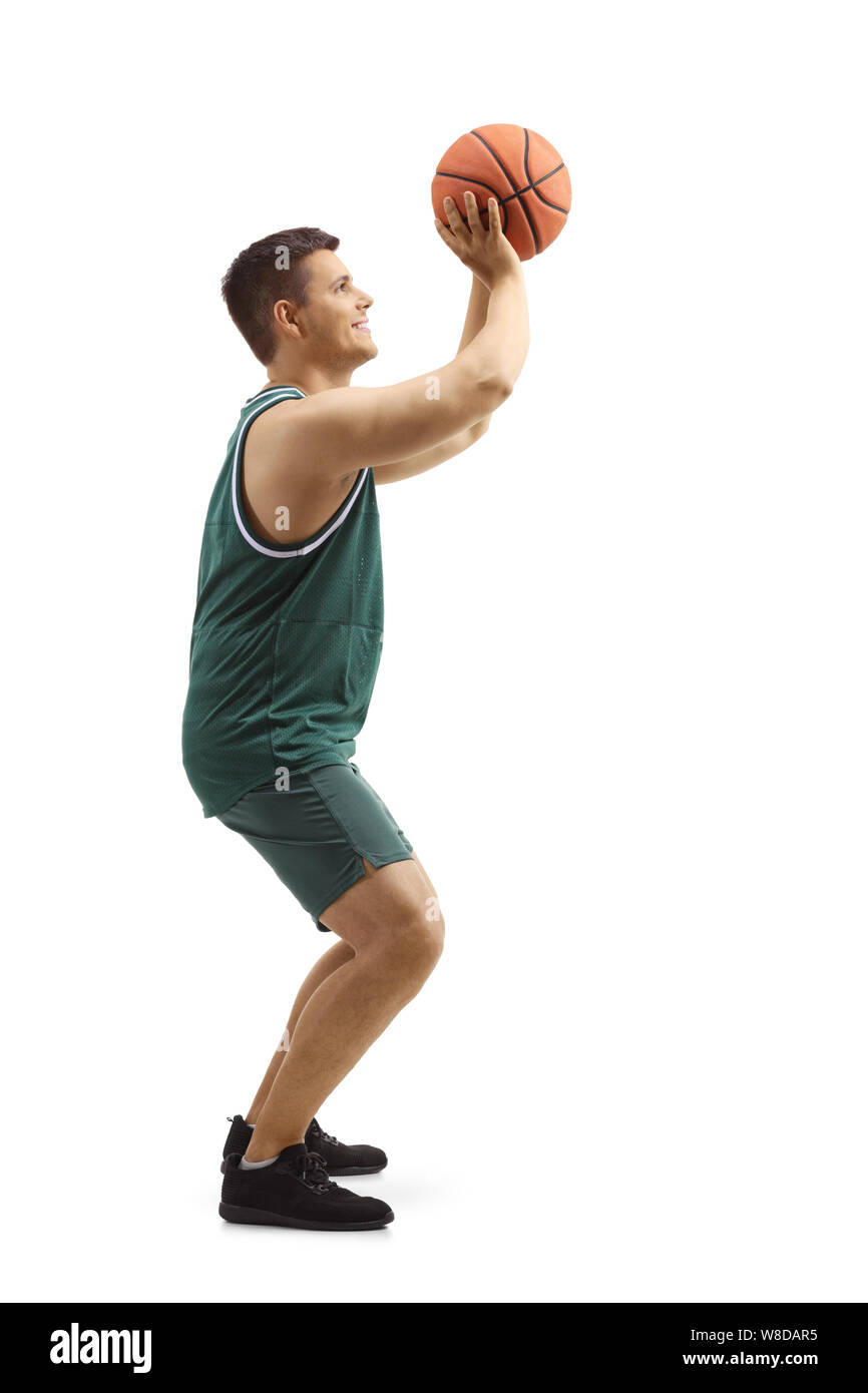 Lunghezza piena ripresa del profilo di un uomo in una maglia sportiva tiro con una palla da basket isolato su sfondo bianco Foto Stock