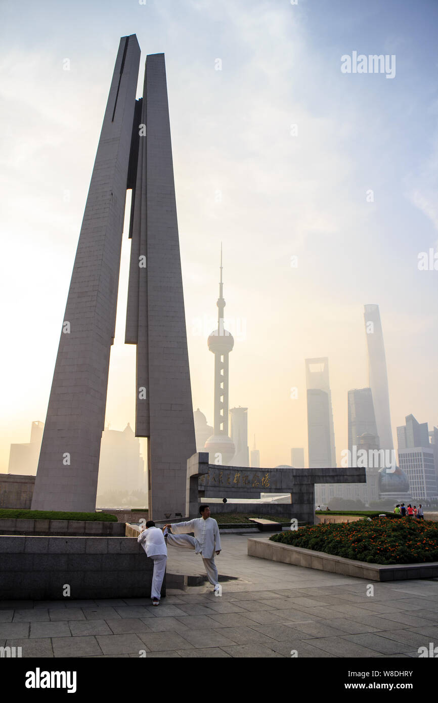 --FILE--cittadini cinesi fare esercizi del mattino presso il monumento al popolo di eroi sul Bund contro lo skyline di Pudong Lujiazui finanziario di Foto Stock