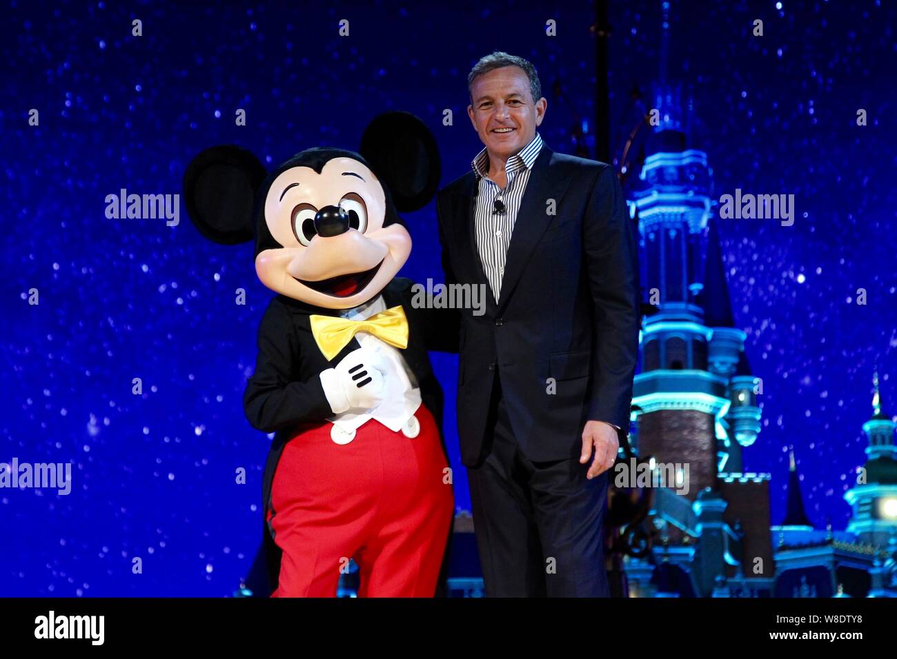 Disney Chairman e CEO Bob Iger, destra, pone con un intrattenitore vestito in un costume di Micky Mouse durante una cerimonia di lancio per svelare una modalità di scala Foto Stock