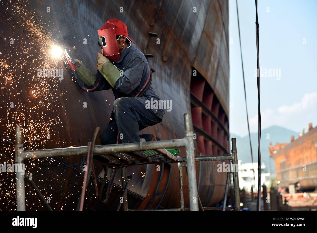 --FILE--un lavoratore cinese saldature nello scafo di una nave ad una nave in fabbrica Yunyang county, Chongqing, la Cina, 12 ottobre 2015. La Cina del tasso di crescita del PIL nell'th Foto Stock
