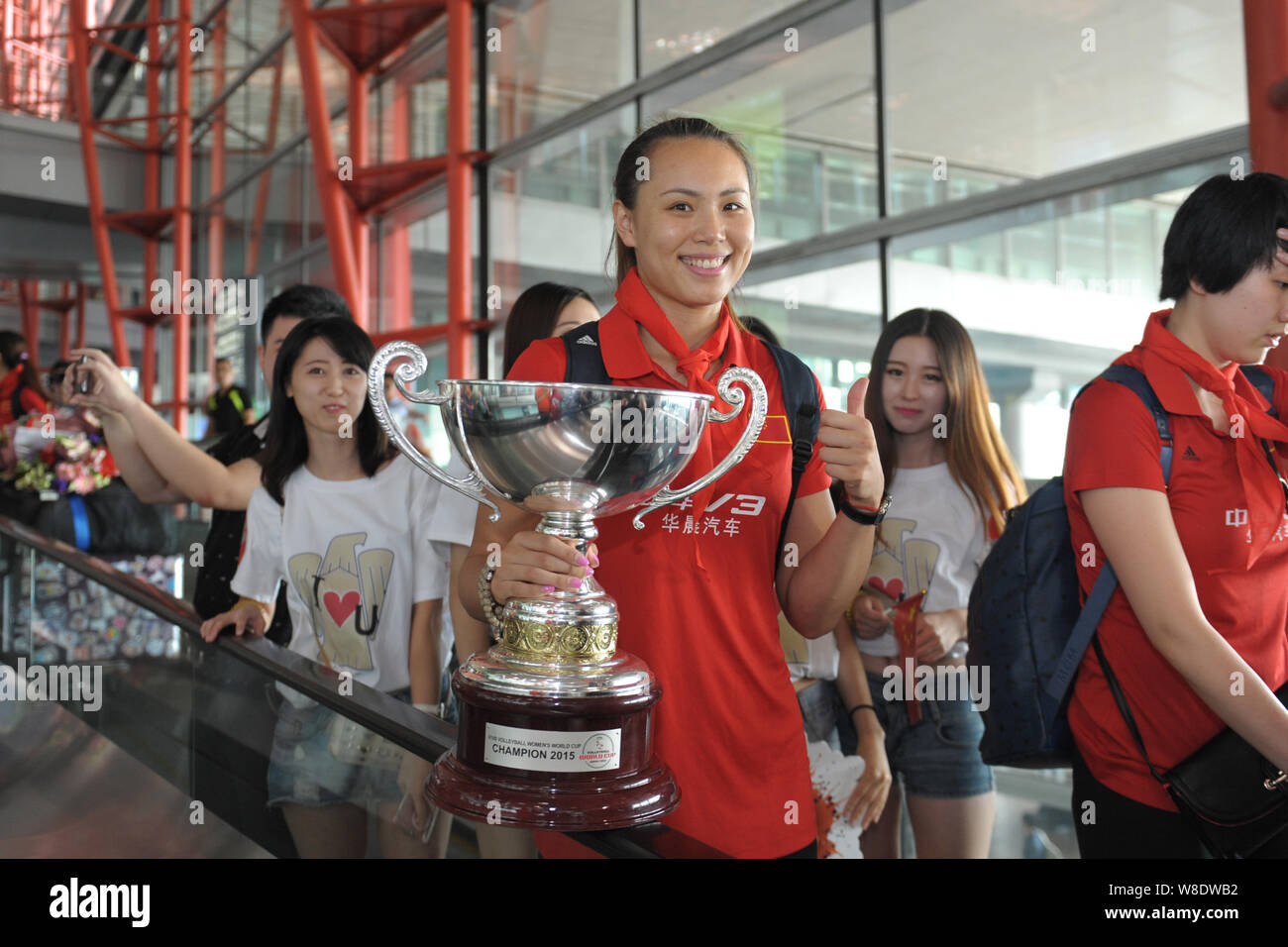 Zeng Chunlei della Cina femminile di pallavolo nazionale team pone con il trofeo dopo il ritorno dal 2015 Femminile di Pallavolo Coppa del Mondo a Pechino Foto Stock