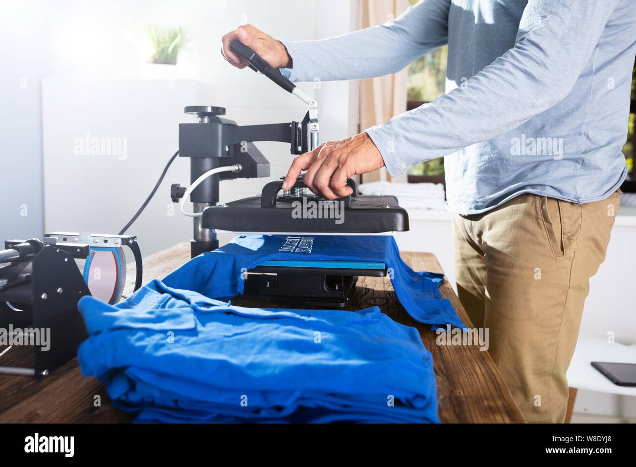 L'uomo immagine di stampa su T-Shirt in officina Foto Stock