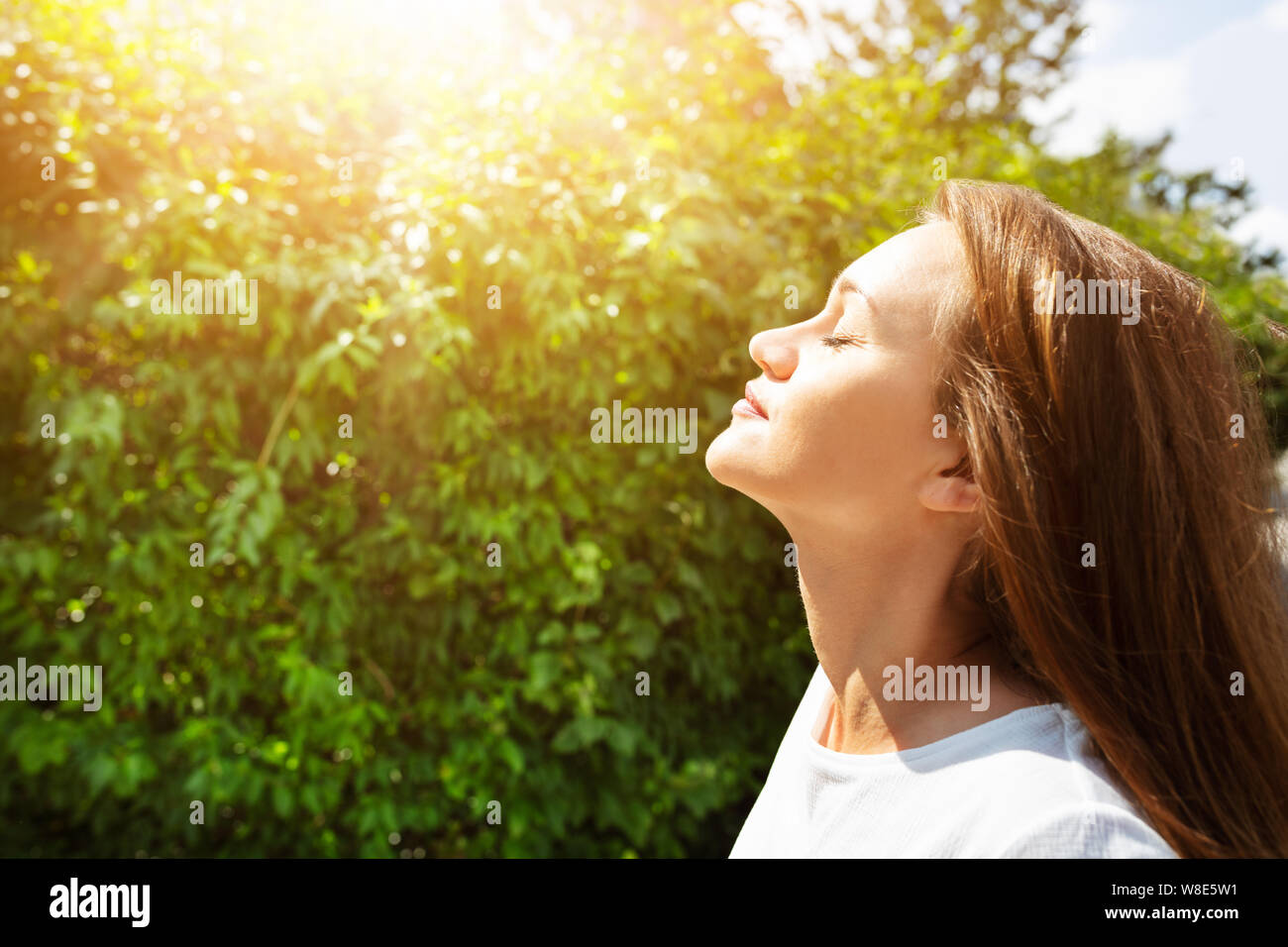 Vista laterale della giovane e bella donna di chiudere gli occhi e respirare aria fresca e pulita Foto Stock
