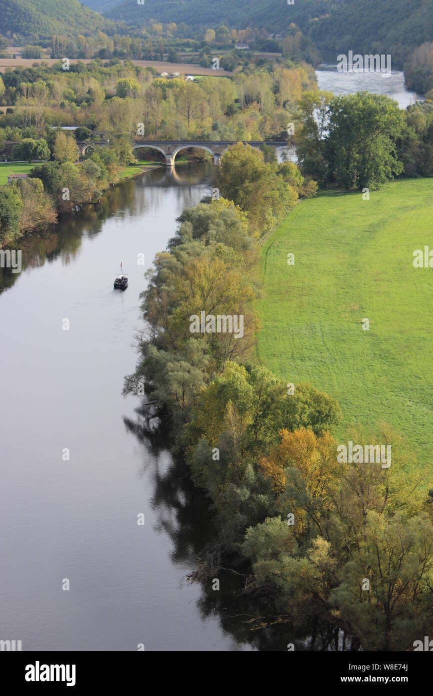 Vista autunnale del fiume Dordogna dal Castello di Beynac. È possibile vedere un 'gabarre', artigianato tipico della regione e un acquedotto che attraversano il fiume Foto Stock