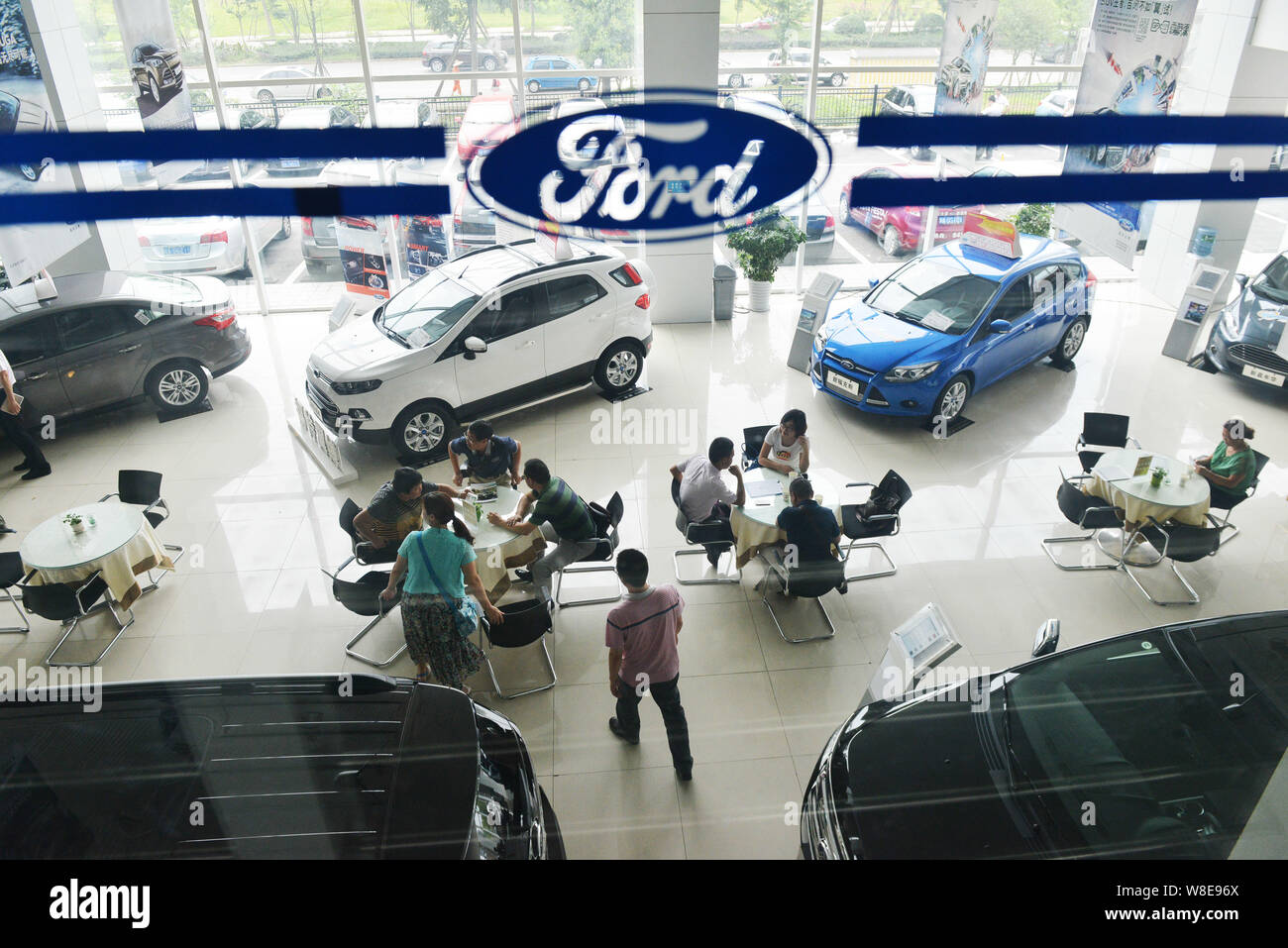 --FILE--cinese gli acquirenti di auto per parlare con la gente di vendite presso un concessionario di Ford nella città di Chengdu, a sud-ovest della Cina di provincia di Sichuan, 23 agosto 2014. Ford Foto Stock