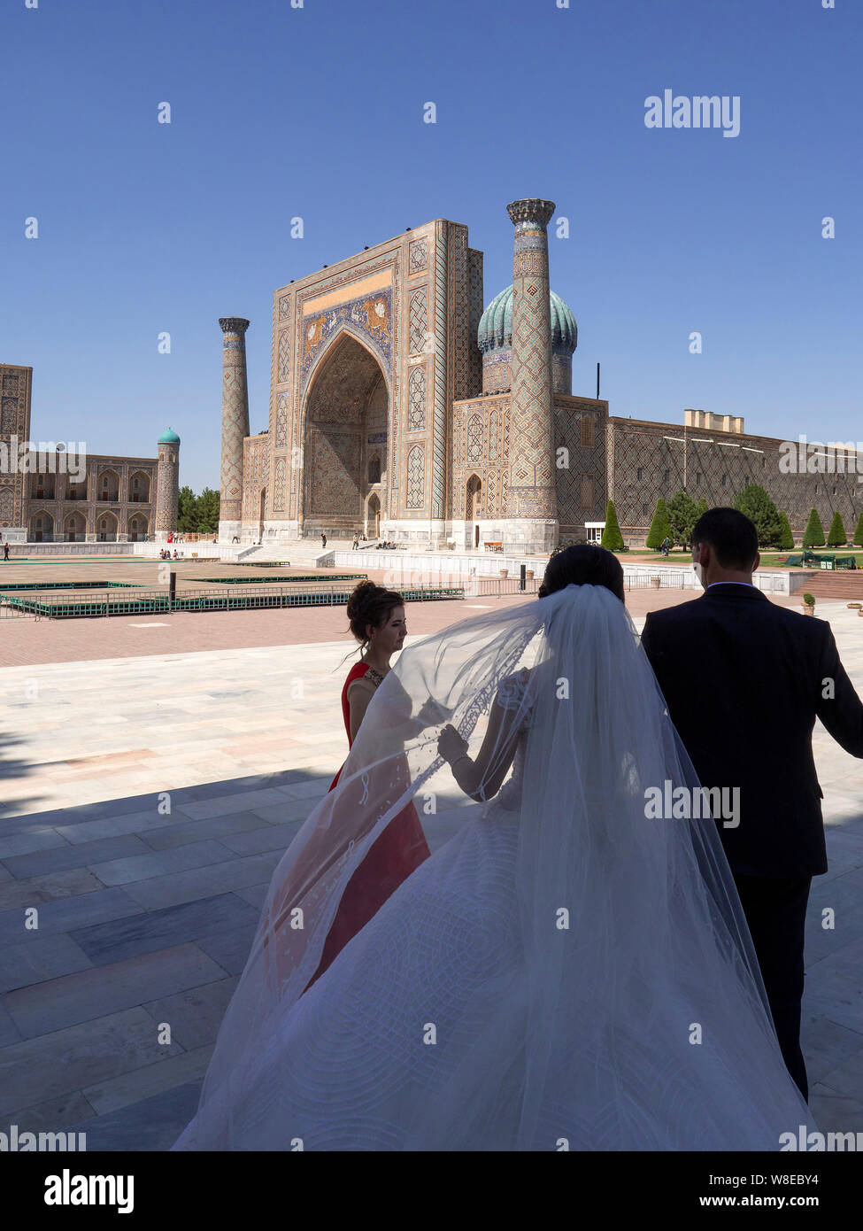Coppia di sposi in Piazza Registan, Samarcanda, Uzbekistan, Asia Foto Stock