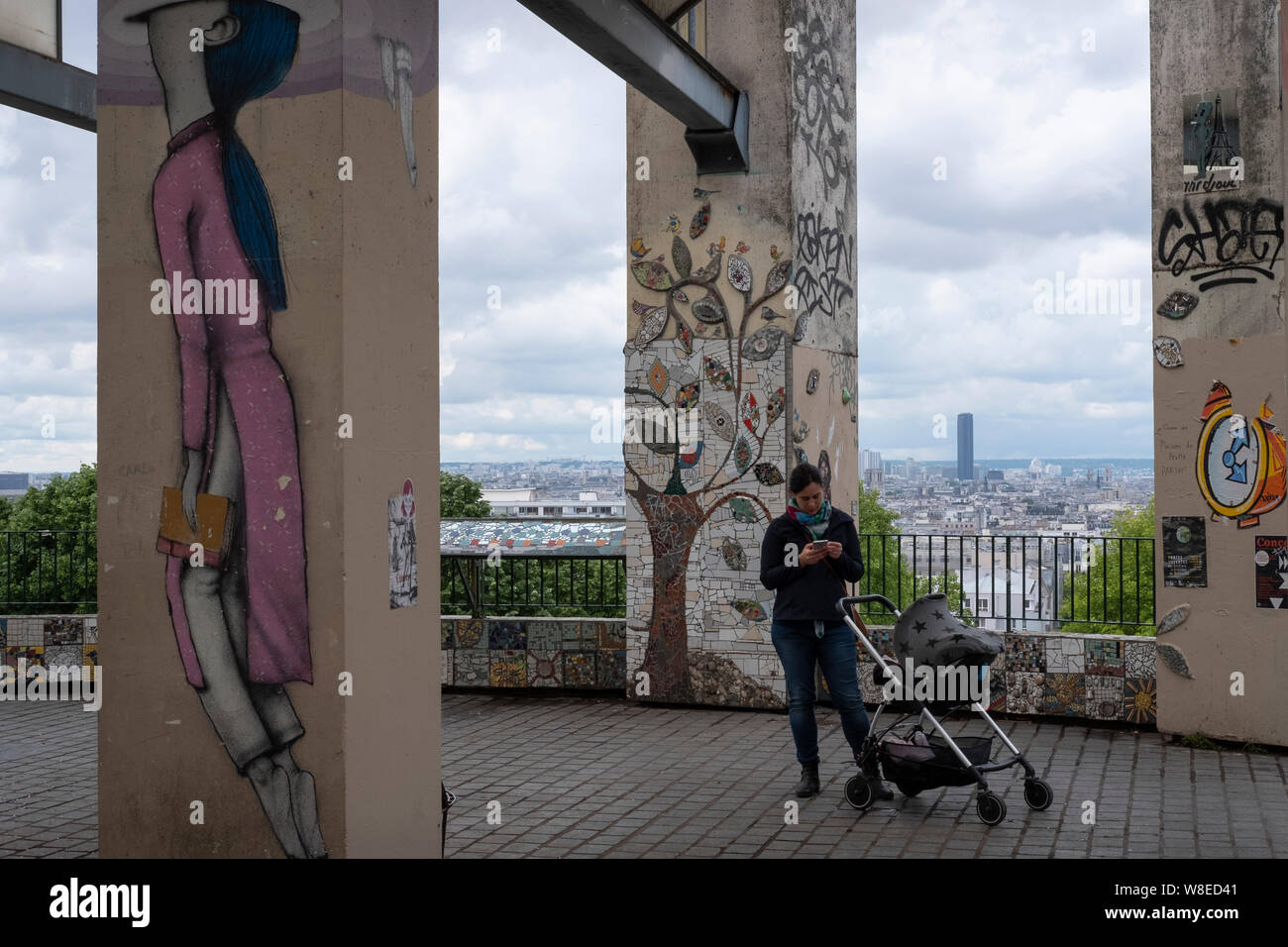 La vita quotidiana a Parigi: la madre e il bambino presso il punto di vista nel quartiere parigino Belville con la torre di Montparnasse in distanza. Foto Stock