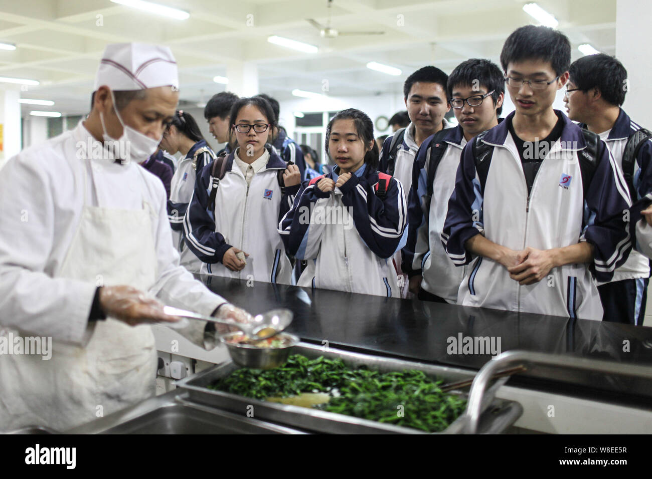 --FILE -- Gli studenti in coda fino a ottenere la loro cena in una mensa per una high school di Hangzhou, a est della Cina di provincia dello Zhejiang, 1 aprile 2014. Persone che ho Foto Stock