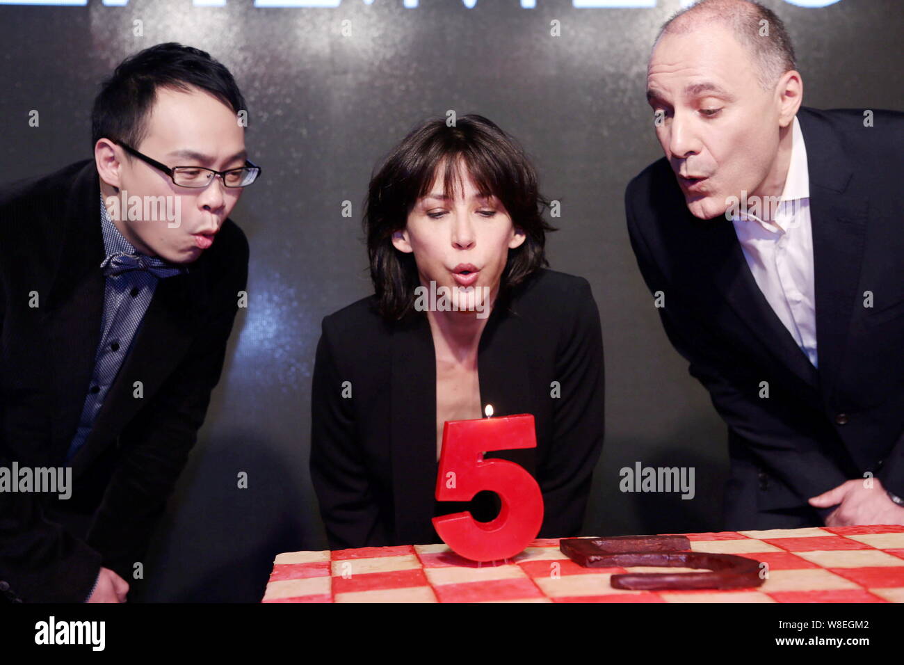 L'attrice francese Sophie Marceau, centro e i dirigenti a soffiare una candela durante un evento di celebrazione per il quinto anniversario della cinese di moda di lusso Foto Stock