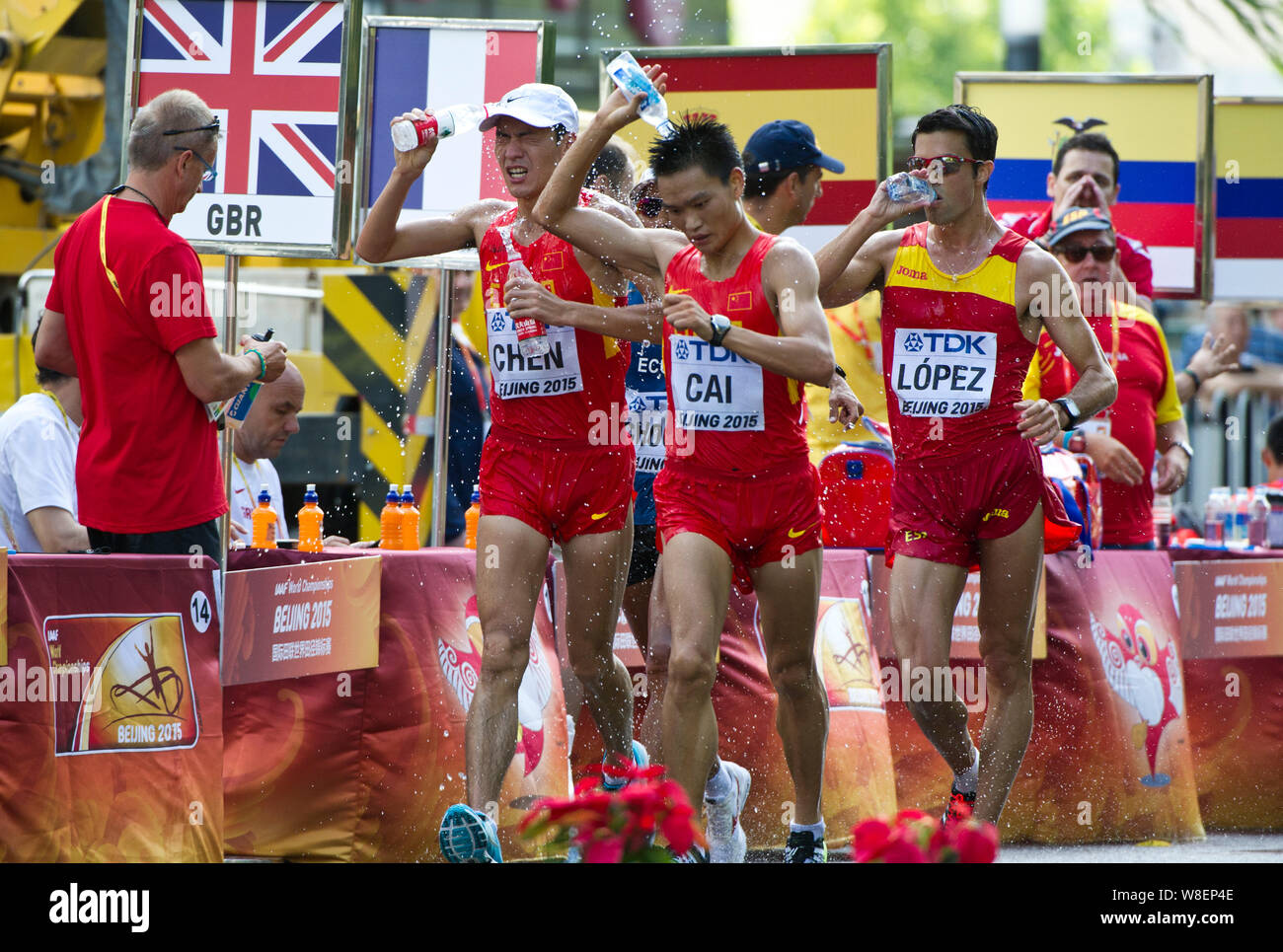 (Da sinistra) della Cina di Chen Ding e Cai Zelin, Spagna Miguel Angel Lopez raffreddare in se stessi con acqua potabile come hanno giocato negli uomini 20km a piedi Foto Stock