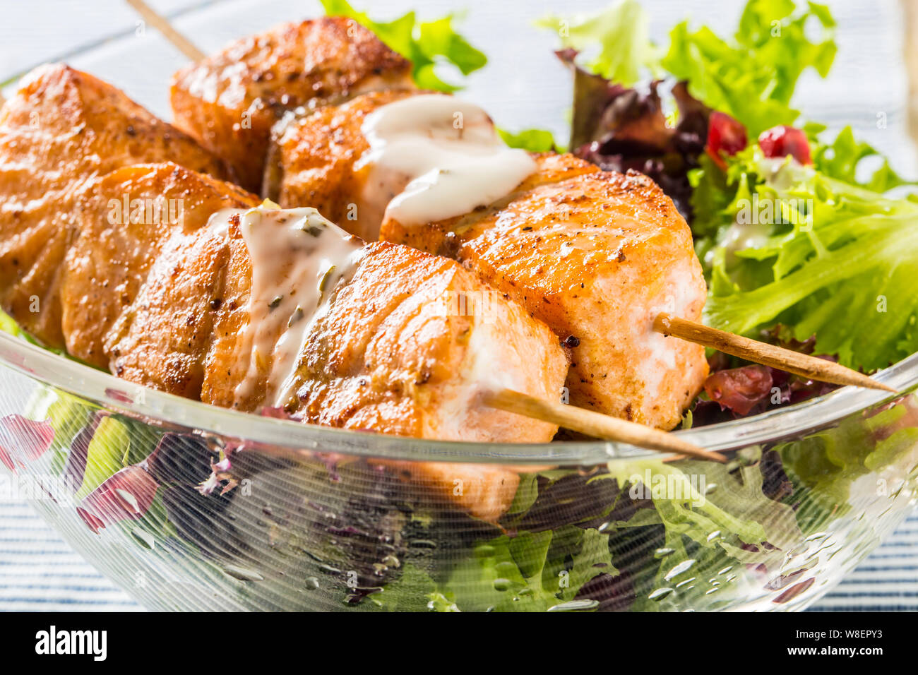 Salmone alla griglia spiedini con insalata estiva salat pomehranate semi Olio d'oliva e condimento. Pesce sano cibo con frutta e verdura Foto Stock