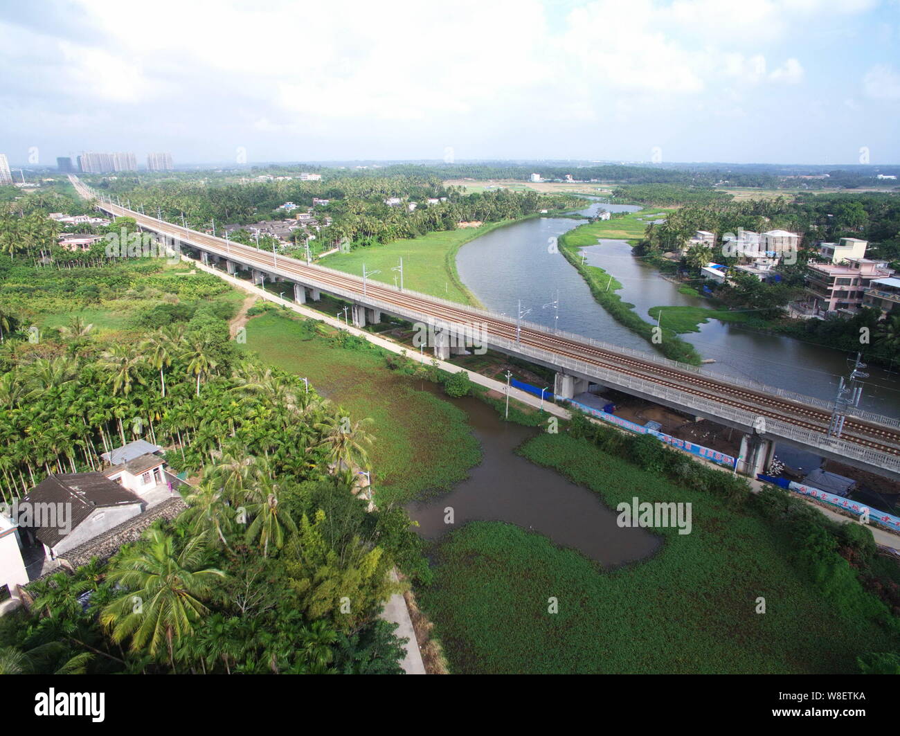 Vista di una sezione del mondo la prima linea ferroviaria ad alta velocità che aleggia un'isola Rongshan village, il centro della città di Haikou, Cina del sud della provincia di Hainan, 29 De Foto Stock