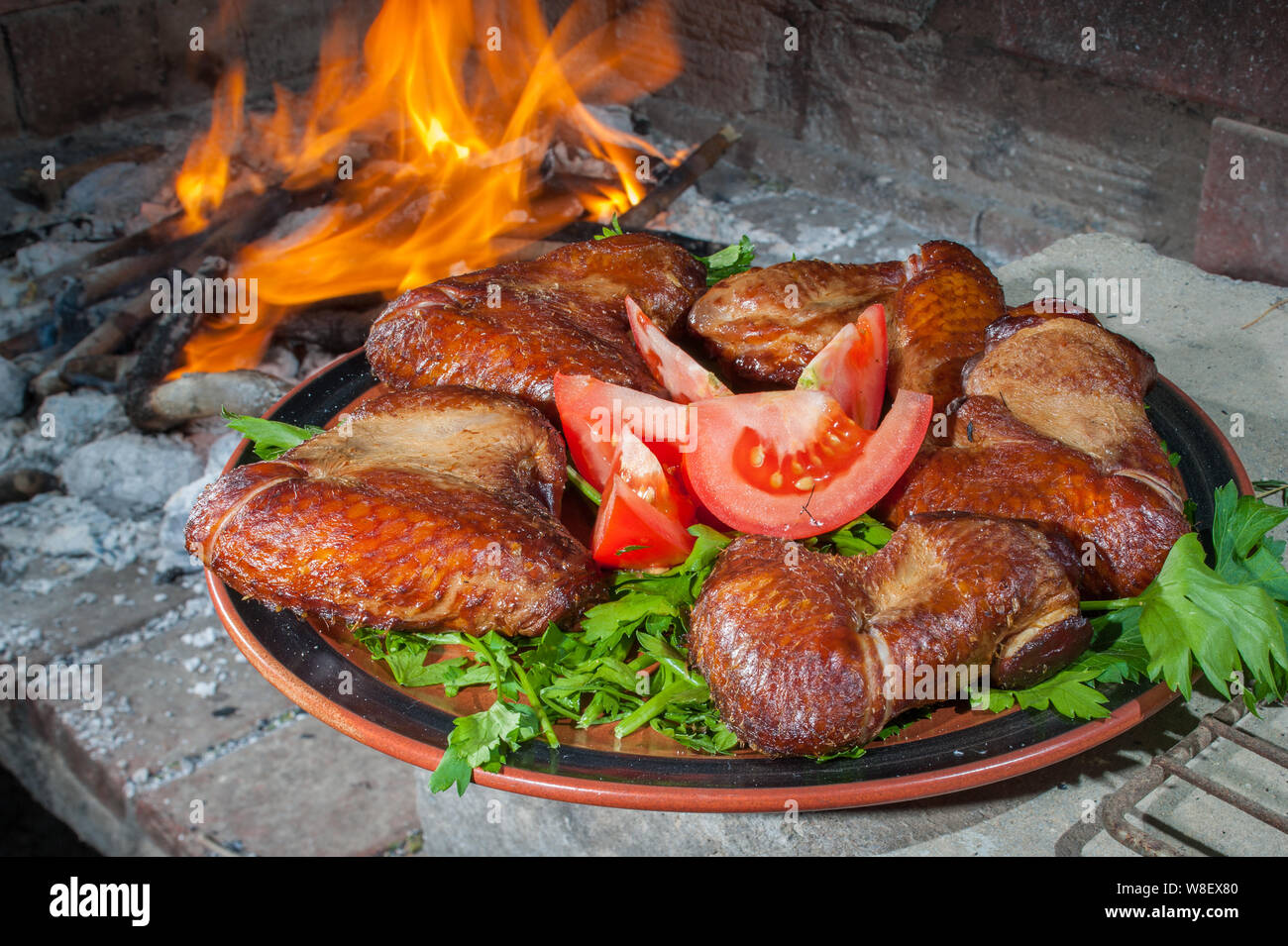 La piastra di chikken affumicato con il carbone che brucia in background Foto Stock