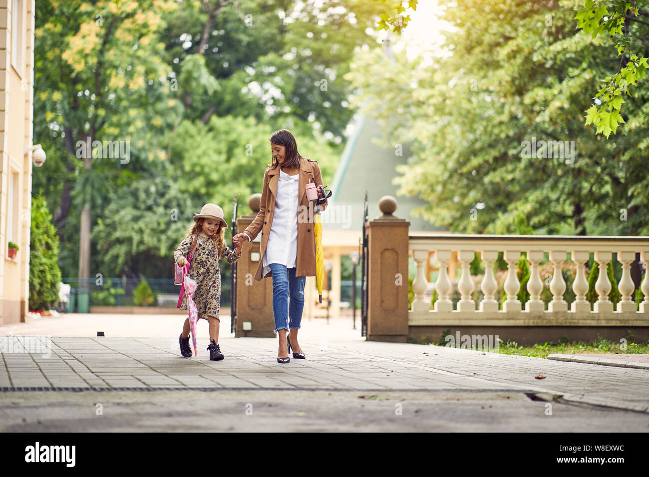 Si torna a scuola. Felice madre e figlia andare alla scuola elementare. Genitore prendendo il bambino alla scuola primaria. Allievo andare con lo studio di uno zaino. Foto Stock