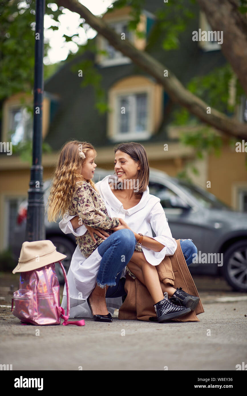 Dopo il primo giorno di scuola, ragazza dire alla mamma come è stato nella scuola Foto Stock