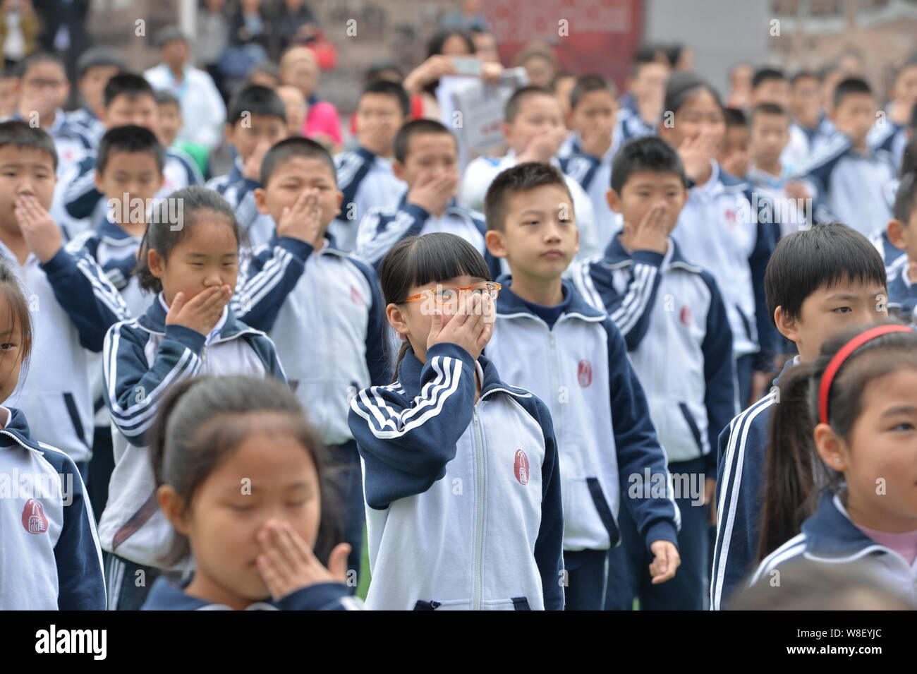 Giovani studenti cinesi per saperne di segnali a mano per allertare i fumatori a smettere di fumare in una scuola di Pechino, Cina, 11 maggio 2015. Gli studenti in avvio di Pechino Foto Stock