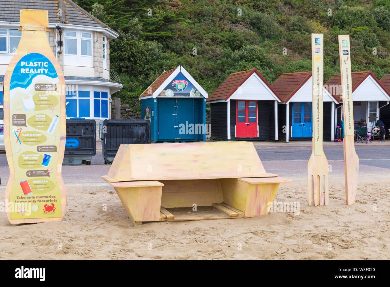 Bournemouth, Dorset UK. 9 agosto 2019. Una nuova installazione d'arte temporanea arriva alla spiaggia di Bournemouth, composta da una cassetta per la takewway, posate in plastica e bottiglia di plastica monouso, il tutto realizzato in legno con messaggi sull'inquinamento plastico e il suo effetto sulla fauna selvatica. Progettato dall'artista Jack Raisey installazioni simili sono state installate sulle spiagge di Lyme Regis e West Bay. Credit: Carolyn Jenkins/Alamy Live News Foto Stock