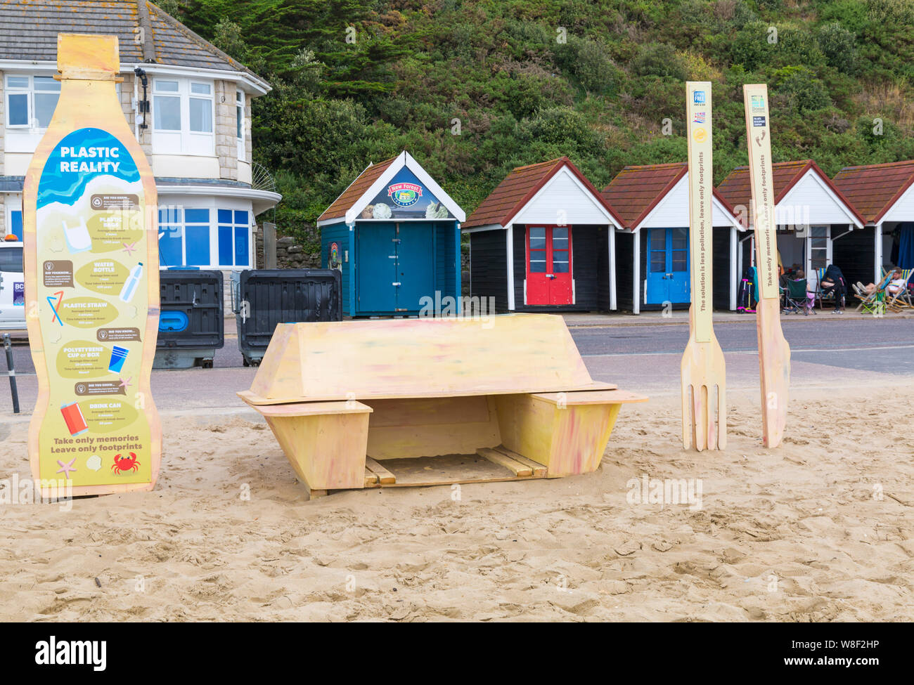 Bournemouth, Dorset UK. 9 agosto 2019. Una nuova installazione d'arte temporanea arriva alla spiaggia di Bournemouth, composta da una cassetta per la takewway, posate in plastica e bottiglia di plastica monouso, il tutto realizzato in legno con messaggi sull'inquinamento plastico e il suo effetto sulla fauna selvatica. Progettato dall'artista Jack Raisey installazioni simili sono state installate sulle spiagge di Lyme Regis e West Bay. Credit: Carolyn Jenkins/Alamy Live News Foto Stock