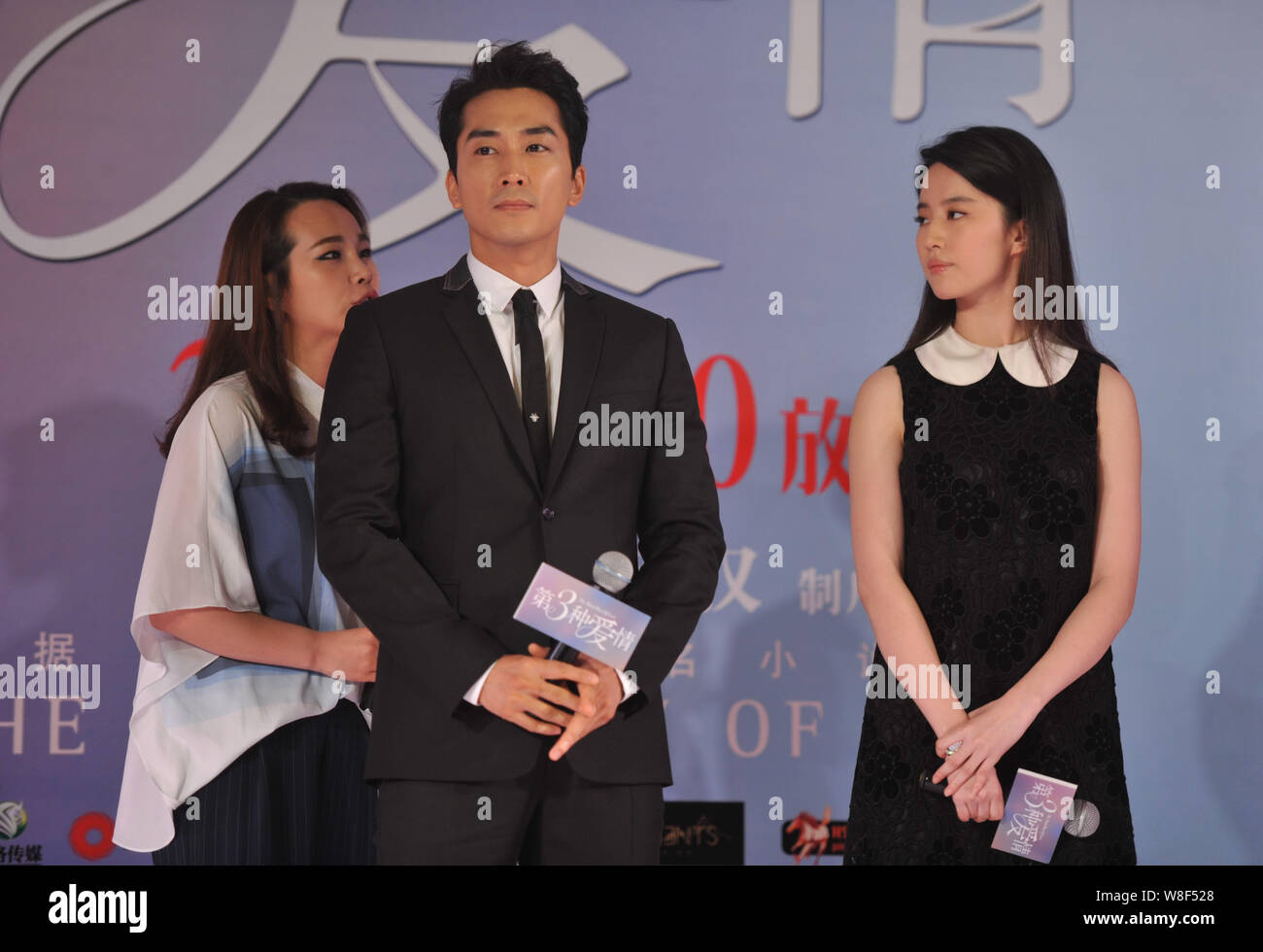 Corea del Sud attore Song Seung-heon, centro, ascolta un interprete accanto alla sua attrice cinese ragazza Liu Yifei, destra, come essi piangono la victi Foto Stock