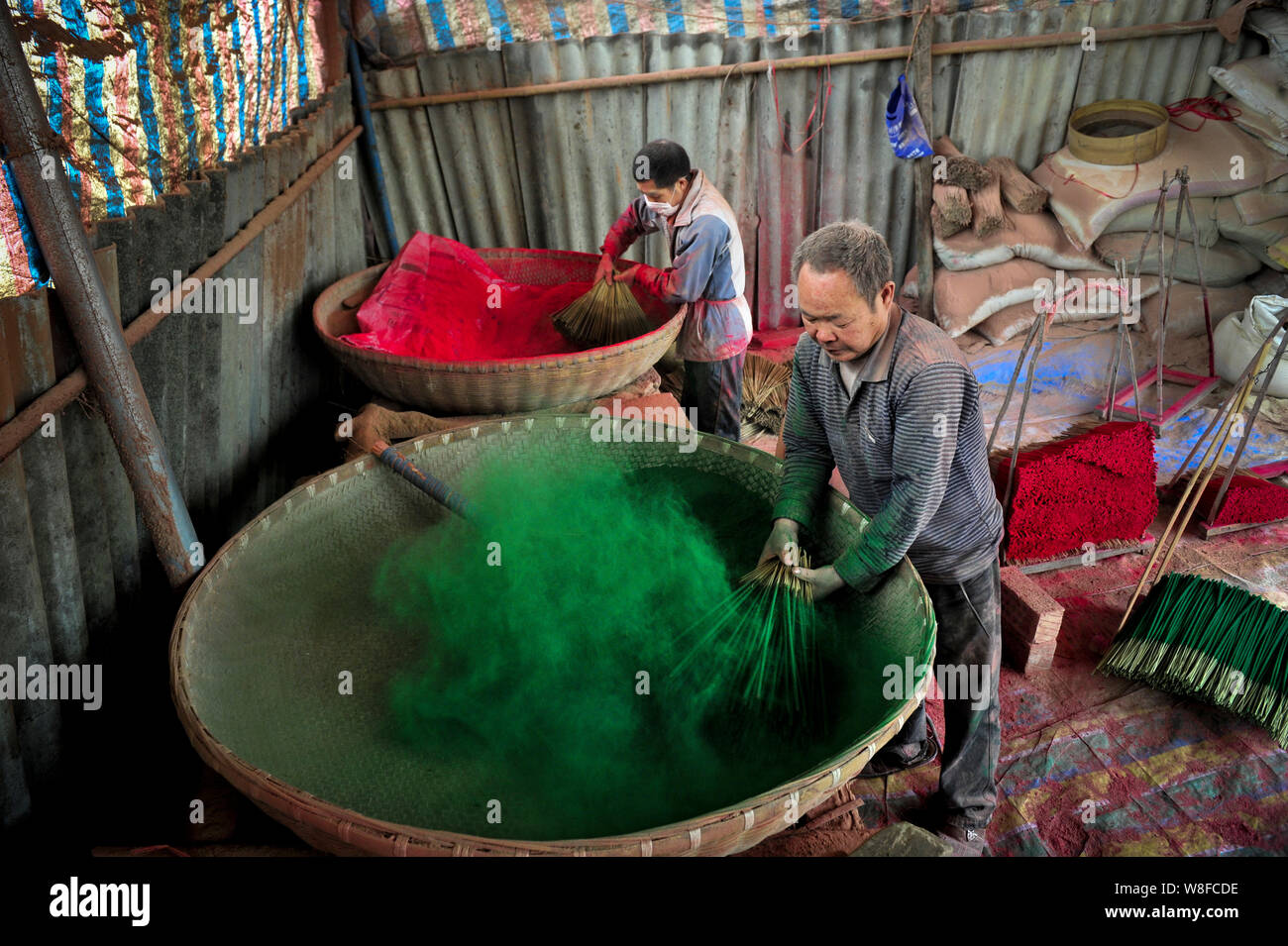 Lavoratori cinesi colorante canne di bambù per rendere i bastoncini di incenso in un laboratorio domestico in Xinchang town, Dayi county, Chengdu, a sud-ovest della Cina di Sichua Foto Stock