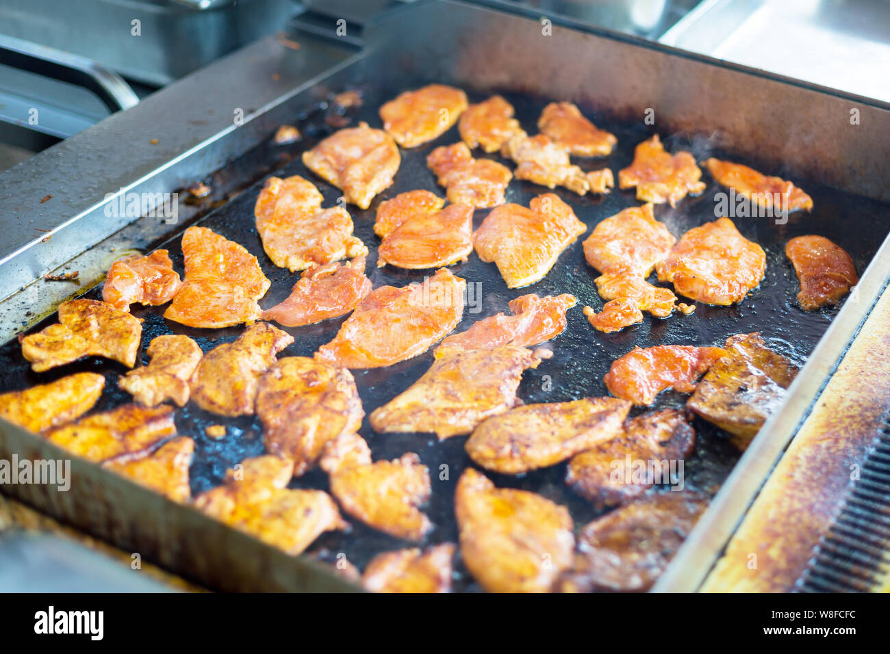 Porzionato pezzi di tritare carne vengono fritte in olio in una cucina aperta. Foto Stock