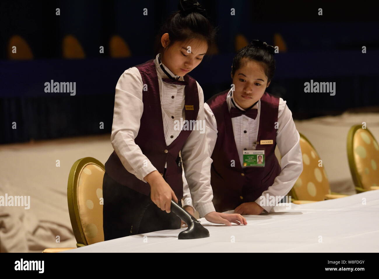I dipendenti cinesi pulire i tavoli davanti al Forum Boao per l Asia Conferenza annuale 2015 alla BFA International Convention Centre di Città Qionghai, così Foto Stock