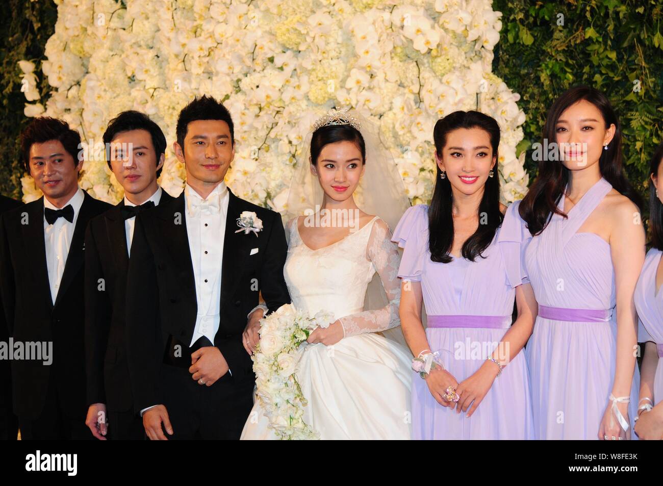 Attore cinese Huang Xiaoming, la terza a sinistra e la sua attrice moglie Angelababy, la terza a destra, rappresentano con la loro groomsmen e damigelle durante il loro matrimonio Foto Stock