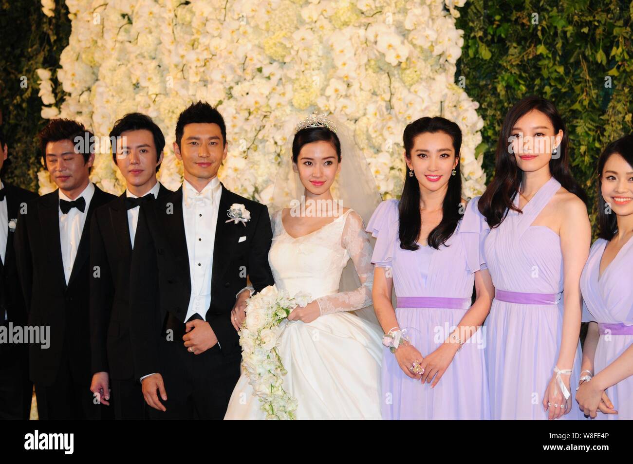 Attore cinese Huang Xiaoming, la terza a sinistra e la sua attrice moglie Angelababy, quarta a destra, rappresentano con la loro groomsmen e damigelle durante il loro weddin Foto Stock